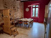 a dining room with a table and a clock on the wall at L&#39;Armandière, maison de caractère où règne calme et sérénité. in Pézenes-les-Mines