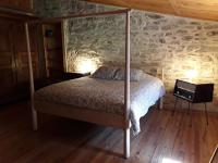a bedroom with a bed in a stone wall at L&#39;Armandière, maison de caractère où règne calme et sérénité. in Pézenes-les-Mines