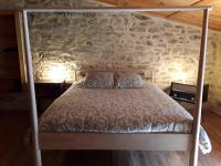 a bed in a room with a stone wall at L&#39;Armandière, maison de caractère où règne calme et sérénité. in Pézenes-les-Mines
