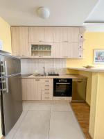 a kitchen with wooden cabinets and stainless steel appliances at Mega Lux Apartment in Vračar (historical)