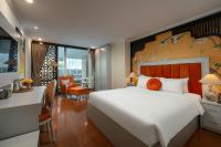 Un dormitorio con una gran cama blanca y un escritorio. en Serenata San de Hanoi Hotel, en Hanói