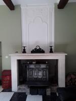 a fireplace with a clock on top of it at L&#39;Armandière, maison de caractère où règne calme et sérénité. in Pézenes-les-Mines