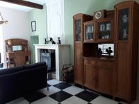 a living room with wooden cabinets and a fireplace at L&#39;Armandière, maison de caractère où règne calme et sérénité. in Pézenes-les-Mines