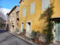 a yellow building on the side of a street at L&#39;Armandière, maison de caractère où règne calme et sérénité. in Pézenes-les-Mines