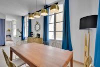 a dining room with a wooden table and blue curtains at Appartements hyper-centre de Marseille in Marseille