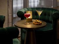 a table with a drink and a wine glass on it at The Playford Adelaide - MGallery in Adelaide