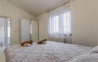 a bedroom with a large bed with a large window at Beautiful Home In Skatari With Outdoor Swimming Pool in Škatari