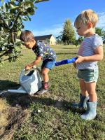 two young boys are playing with a lawn mower at Gite du Moulin in Saint-Laurent-dʼAndenay