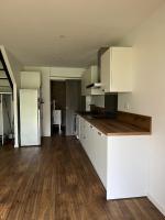 a kitchen with white cabinets and a wooden floor at Le Sailhet, maison de vacances in Pierrefitte-Nestalas