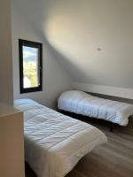 two beds in a room with a window at Le Sailhet, maison de vacances in Pierrefitte-Nestalas