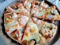 een pizza met kaas en champignons op een bord bij Mountain View Guest House in Phatthalung