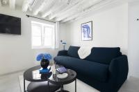 a living room with a blue couch and a table at Appartement Vertus in Paris