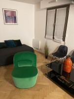 a living room with a green chair and a bed at 45 m2 private apartment in Paris in Paris