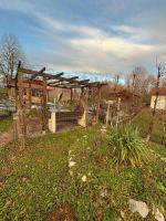 a wooden pergola with a bench in a yard at VILLA M Slatina Banja Luka 