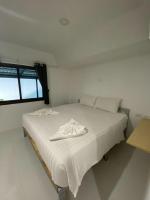 a white bed in a room with a window at Samui Green Hotel in Chaweng