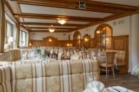 Un salón de banquetes con mesas y sillas y un buscador de mesas. en Hotel Asterbel, en Braies