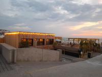 a building with lights on it next to the ocean at "Le JUGUILI" 46m2 en front de Mer - 4 personnes - animaux OK - Entièrement rénové - Haut de gamme - wifi in Mers-les-Bains