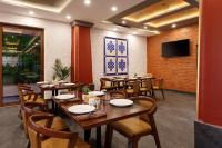 a restaurant with wooden tables and chairs and a flat screen tv at Atisha Hotel in Kathmandu