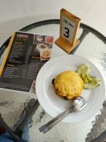 Un plato de comida sobre una mesa de cristal con un cuchillo y un tenedor. en NK Villa Syariah And Cafe Prigen, en Pasuruan