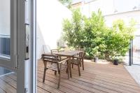 a patio with a wooden table and chairs on a balcony at Tranquilis - Studio hypercentre terrasse parking in Reims