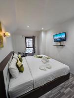 a bedroom with a large bed with a tv on the wall at Samui Green Hotel in Chaweng