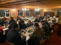 un grupo de personas sentadas en mesas largas comiendo en Hotel De Rust, en De Rust