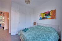a bedroom with a bed and a painting on the wall at The Rooftop - AC CLIM - Wi-Fi - Parking gratuit dans la rue in Avignon
