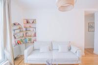 a white couch in a living room with bookshelves at *Cozy flat-Latin Quarter in the heart of Paris* in Paris