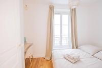 a white bed in a room with a window at *Cozy flat-Latin Quarter in the heart of Paris* in Paris