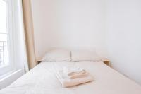 a white bed with two towels sitting on it at *Cozy flat-Latin Quarter in the heart of Paris* in Paris
