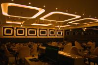 Un restaurante con sillas y mesas blancas y un monitor. en Hotel Tanisha, en Kishanganj Bazar