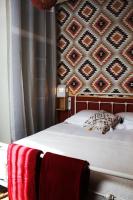 a bed with a red blanket and a wall with at Eau Berges in Vicdessos