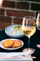a table with a plate of food and a glass of wine at Hotel Kakola in Turku