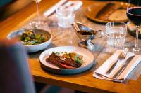 a wooden table with plates of food and wine at Hotel Kakola in Turku