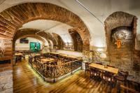 a restaurant with brick walls and wooden tables and chairs at Martin Hotel Prague in Prague