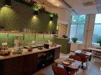 Una cocina con mesas y sillas en un restaurante. en ApartHotel Waepen van Middelburg, en Middelburg