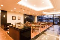 a restaurant with tables and chairs and windows at The Loft Seaside Suites in Jinshan