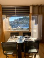 a dining room table with chairs and a large window at Studio Cabine Chaleureux 4 Personnes Pied des Pistes Pyrénées 2000 in Bolquere Pyrenees 2000