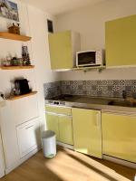 a kitchen with green cabinets and a microwave at Studio Cabine Chaleureux 4 Personnes Pied des Pistes Pyrénées 2000 in Bolquere Pyrenees 2000