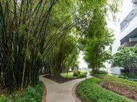 a walkway through a park with trees at Chatrium Hotel Riverside Bangkok in Bangkok