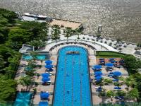 an overhead view of a swimming pool with umbrellas and the water at Chatrium Hotel Riverside Bangkok in Bangkok