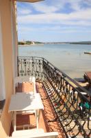 a balcony with a table and a view of the beach at Apartments by the sea Kraj, Pasman - 3460 in Pašman