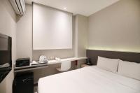 a hotel room with a white bed and a window at Cityinn Hotel Taipei Station Branch I in Taipei