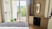 a bedroom with a bed and a mirror and a balcony at Mini Summer in Nanwan
