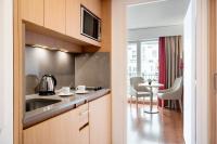 a kitchen with a sink and a table with chairs at Residhome Paris-Evry in Courcouronnes