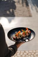 a person holding a plate with food on it at White Dunes Luxury Boutique Hotel in Santa Maria