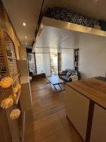 a kitchen and living room with a couch and a table at Studio cosy et moderne aux pieds des pistes in LʼHuez