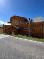 a large wooden building on the side of a road at Studio cosy et moderne aux pieds des pistes in LʼHuez