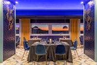 a dining room with a table and blue chairs at Villa Aragonese Rooms in Monte di Procida