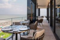 een restaurant met tafels en stoelen en uitzicht op de oceaan bij The Promenade Luxury Wellness Hotel in Riccione